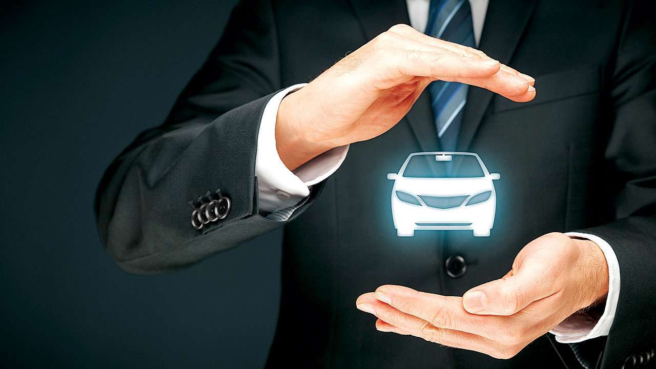 Representative image of two hands protecting a car; symbolic of car insurance